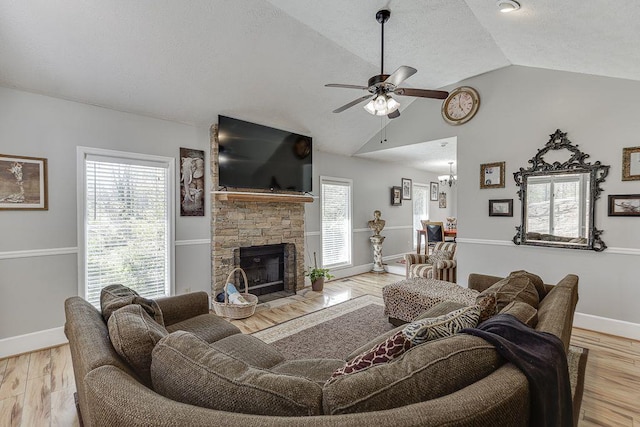 4434 Hidden Oaks Dr, Flowery Branch, GA 30542 - living room featuring ceiling fan, lofted ceiling, wood finished floors, a fireplace, and a textured ceiling