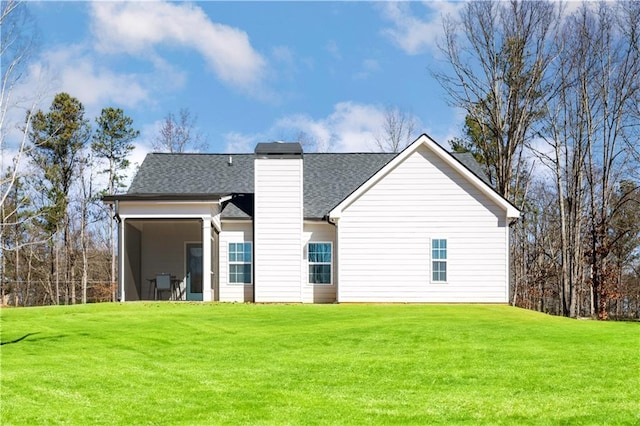 rear view of property featuring a lawn