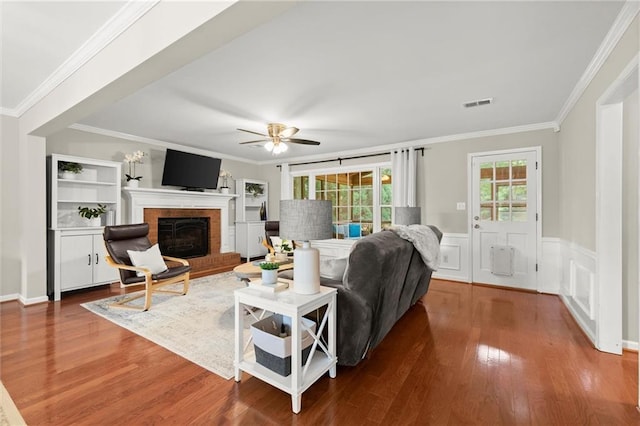 4504 Reva Way NE, Marietta, GA 30066 - living room featuring crown molding, wood finished floors, a brick fireplace, ceiling fan, and a wainscoted wall