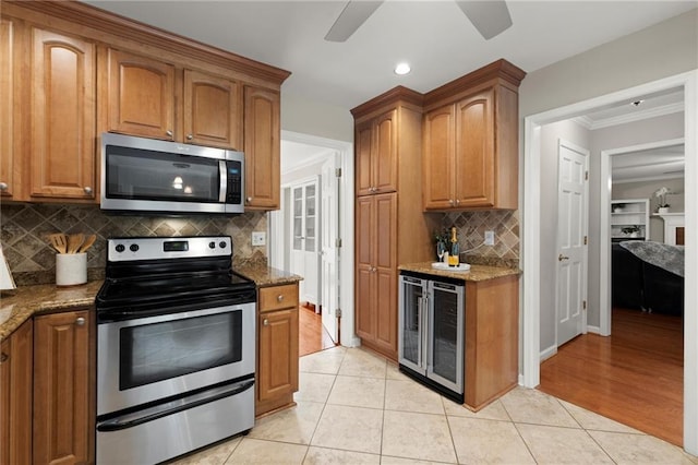 4504 Reva Way NE, Marietta, GA 30066 - kitchen featuring stainless steel appliances, wine cooler, ornamental molding, ceiling fan, and stone counters