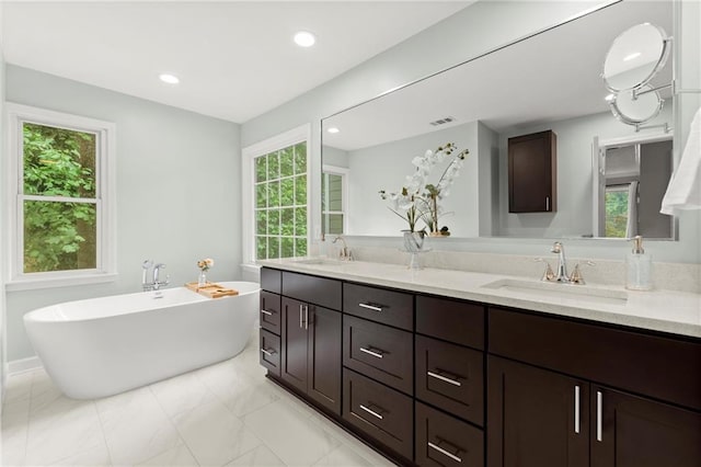4504 Reva Way NE, Marietta, GA 30066 - bathroom with double vanity, plenty of natural light, a freestanding tub, marble finish flooring, and recessed lighting