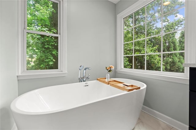 4504 Reva Way NE, Marietta, GA 30066 - full bathroom featuring plenty of natural light, a freestanding bath, marble finish floors, and baseboards