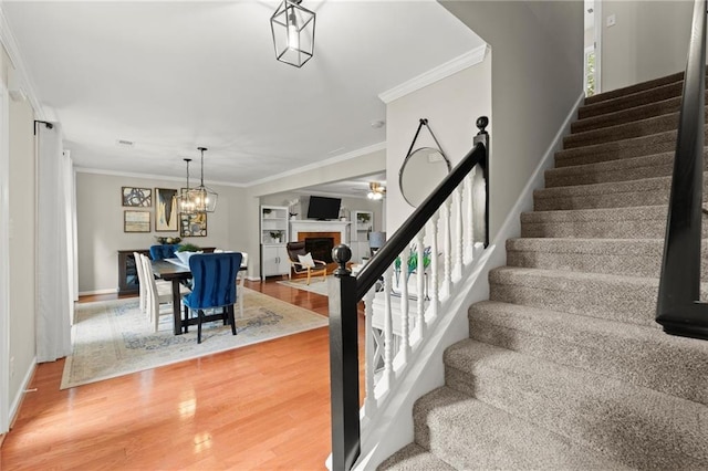 4504 Reva Way NE, Marietta, GA 30066 - staircase with wood finished floors, crown molding, a fireplace, a ceiling fan, and baseboards