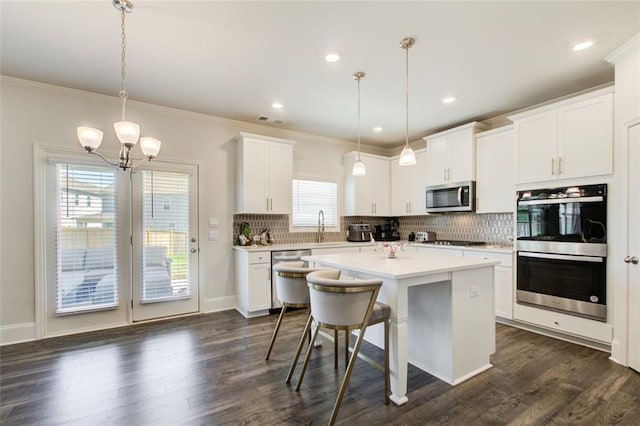 42 Citrine Way, Acworth, GA 30101 - kitchen featuring appliances with stainless steel finishes, backsplash, light countertops, a chandelier, and a center island
