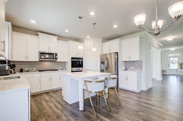 42 Citrine Way, Acworth, GA 30101 - kitchen with appliances with stainless steel finishes, a sink, a kitchen island, decorative backsplash, and wood finished floors