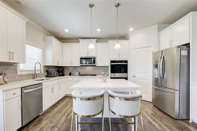 42 Citrine Way, Acworth, GA 30101 - kitchen with appliances with stainless steel finishes, a center island, a sink, ornamental molding, and white cabinetry