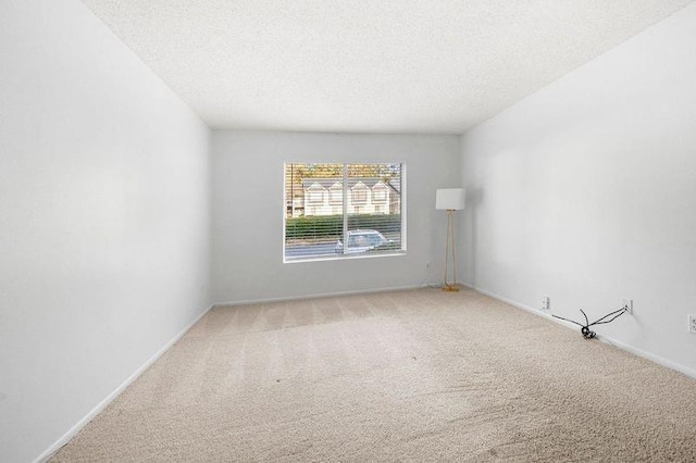 carpeted spare room with a textured ceiling