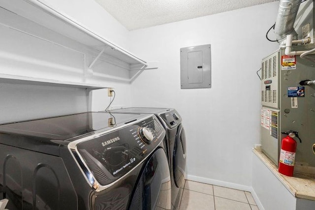 laundry area featuring baseboards, electric panel, laundry area, light tile patterned floors, and separate washer and dryer