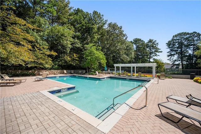 pool featuring a pergola, a patio area, and fence