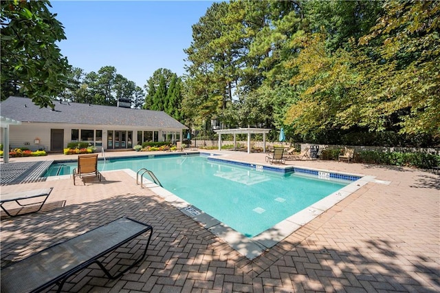 pool featuring a pergola, a patio, and fence