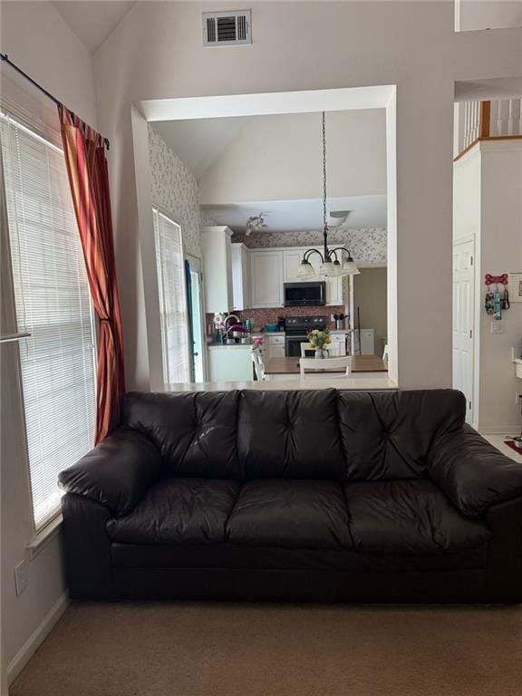 275 Rose Ivy Ct, Lawrenceville, GA 30043 - carpeted living room featuring visible vents, baseboards, and vaulted ceiling