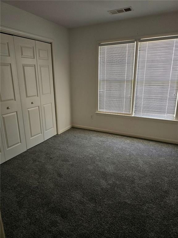 275 Rose Ivy Ct, Lawrenceville, GA 30043 - unfurnished bedroom featuring carpet flooring, visible vents, a closet, and baseboards