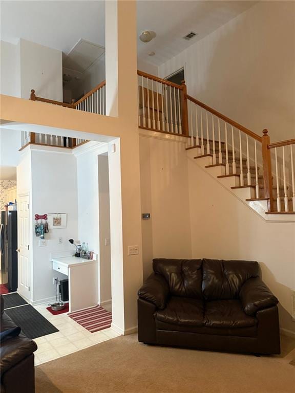 275 Rose Ivy Ct, Lawrenceville, GA 30043 - living room featuring a towering ceiling, baseboards, stairway, carpet flooring, and visible vents