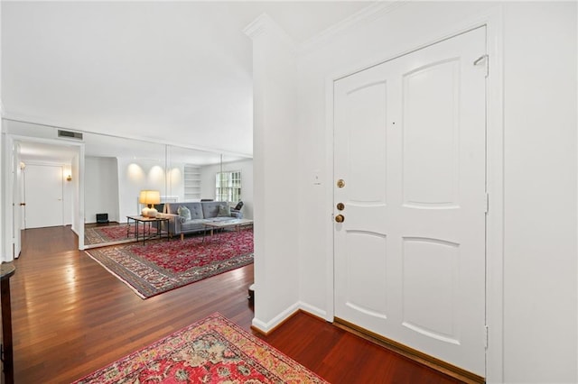 foyer entrance featuring wood finished floors, baseboards, and ornamental molding