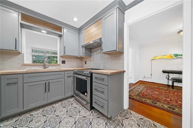kitchen featuring gray cabinetry, high end stove, decorative backsplash, a sink, and recessed lighting