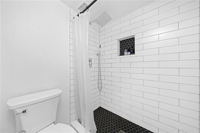full bathroom featuring toilet and a shower stall