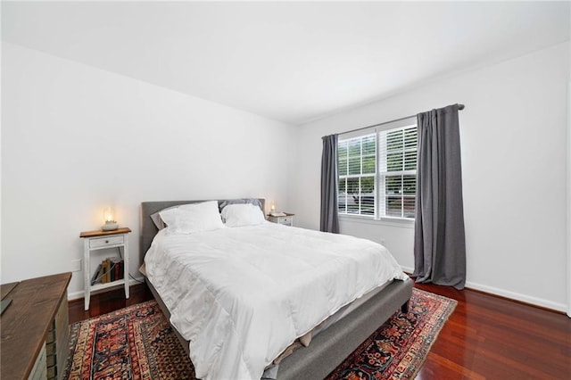bedroom with wood finished floors and baseboards