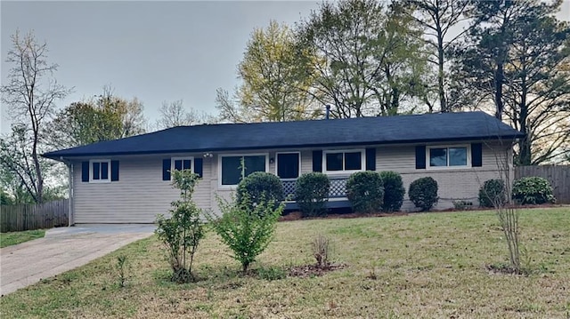 ranch-style home featuring a front lawn and fence