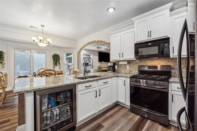 kitchen featuring decorative backsplash, stainless steel appliances, beverage cooler, a notable chandelier, and white cabinets