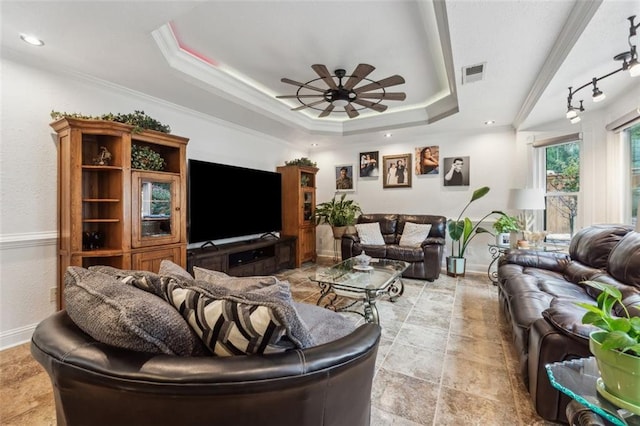 living room featuring ceiling fan, a raised ceiling, and crown molding