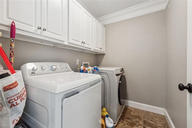 washroom with cabinets, ornamental molding, and washing machine and clothes dryer