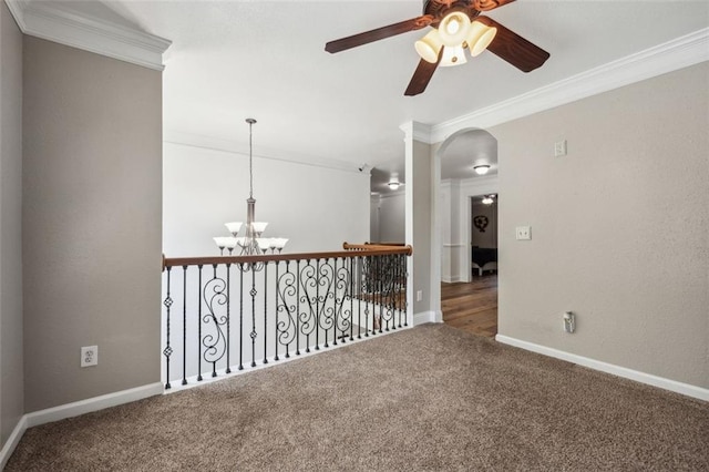 empty room featuring carpet flooring, crown molding, and ceiling fan with notable chandelier