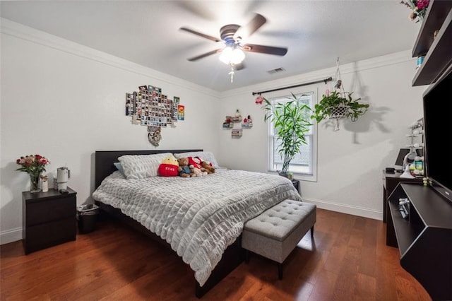 bedroom featuring crown molding, ceiling fan, and dark wood-type flooring