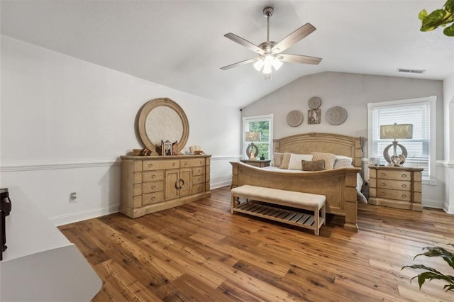 bedroom featuring hardwood / wood-style floors, ceiling fan, lofted ceiling, and multiple windows