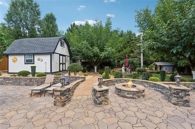 view of patio / terrace featuring an outdoor structure and an outdoor fire pit