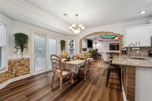 dining room featuring crown molding, dark hardwood / wood-style flooring, a chandelier, and sink