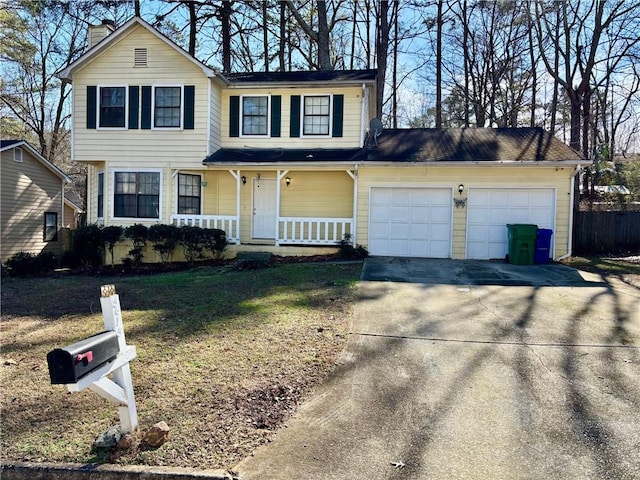 view of front property with a garage, a front yard, and covered porch