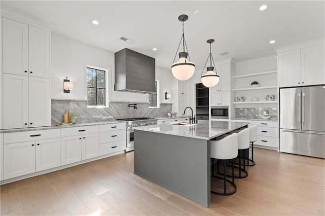 56 Pine St, Roswell, GA 30075 - kitchen with high quality appliances, wall chimney range hood, open shelves, backsplash, and light wood-style flooring