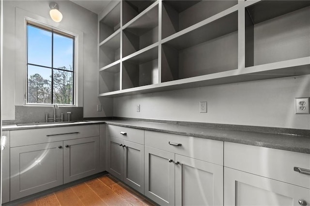 56 Pine St, Roswell, GA 30075 - kitchen featuring open shelves, a sink, wood finished floors, gray cabinetry, and dark countertops