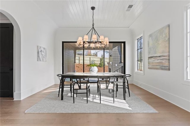 56 Pine St, Roswell, GA 30075 - dining space featuring wood finished floors, a chandelier, baseboards, and arched walkways