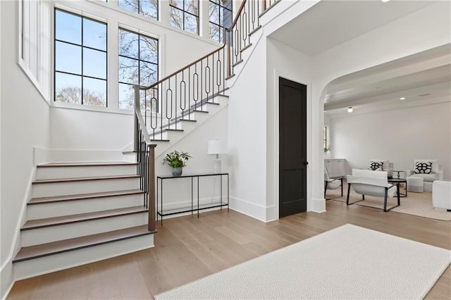 56 Pine St, Roswell, GA 30075 - stairway with wood finished floors, arched walkways, baseboards, and a high ceiling