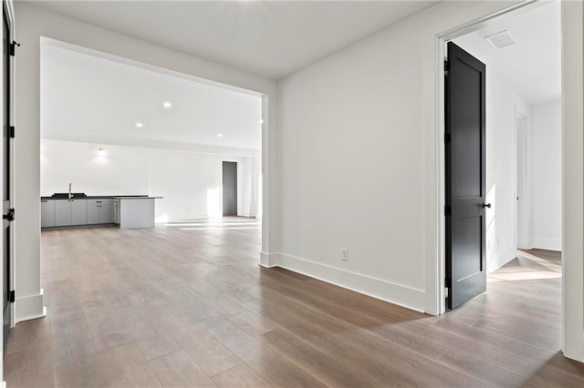 56 Pine St, Roswell, GA 30075 - unfurnished living room featuring wood finished floors, a sink, and baseboards