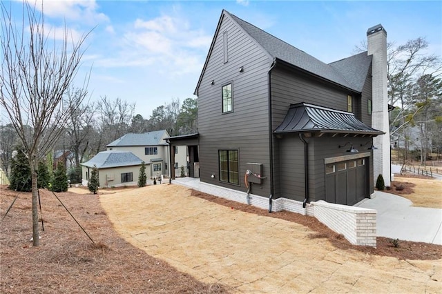56 Pine St, Roswell, GA 30075 - back of property with driveway, a chimney, metal roof, a standing seam roof, and a garage
