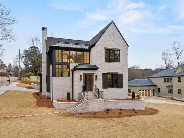 56 Pine St, Roswell, GA 30075 - view of front of house with a standing seam roof, brick siding, a chimney, driveway, and metal roof