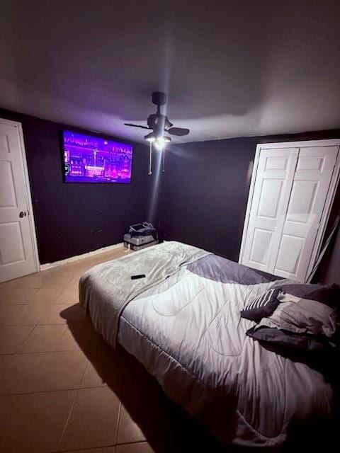 tiled bedroom with baseboards and a ceiling fan