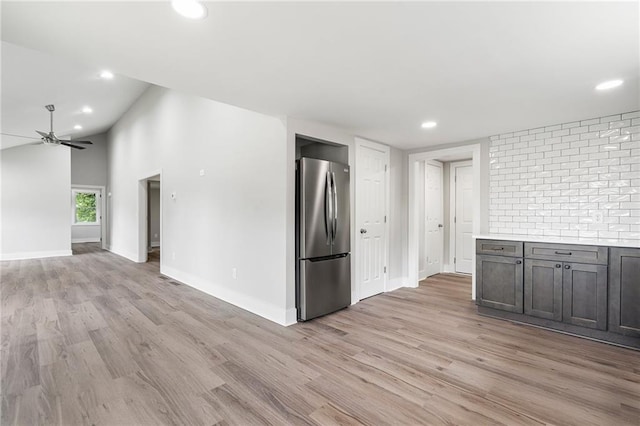 kitchen featuring light wood finished floors, ceiling fan, freestanding refrigerator, and light countertops