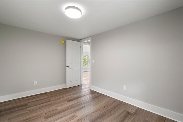 spare room with wood finished floors and baseboards