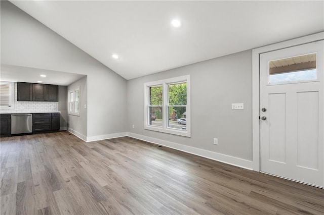 unfurnished living room featuring recessed lighting, vaulted ceiling, wood finished floors, and baseboards