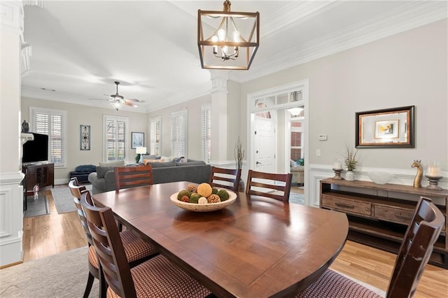 8730 Parker Pl, Roswell, GA 30076 - dining space featuring light wood-style floors, crown molding, ornate columns, a ceiling fan, and wainscoting