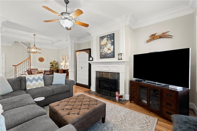8730 Parker Pl, Roswell, GA 30076 - living area featuring wood finished floors, ornamental molding, a ceiling fan, a tile fireplace, and stairs