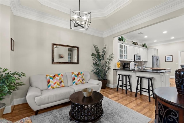 8730 Parker Pl, Roswell, GA 30076 - living area featuring light wood-style floors, a chandelier, recessed lighting, ornamental molding, and baseboards