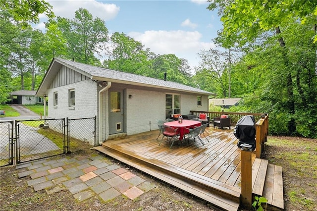 1118 Creekdale Dr, Clarkston, GA 30021 - back of property featuring outdoor dining area, a gate, brick siding, board and batten siding, and a wooden deck