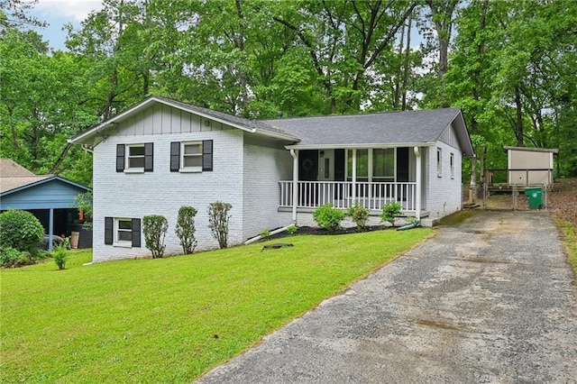 1118 Creekdale Dr, Clarkston, GA 30021 - view of front of house featuring brick siding, a porch, a front yard, and asphalt driveway