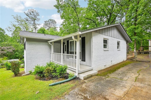 1118 Creekdale Dr, Clarkston, GA 30021 - view of side of home featuring brick siding, covered porch, crawl space, and board and batten siding