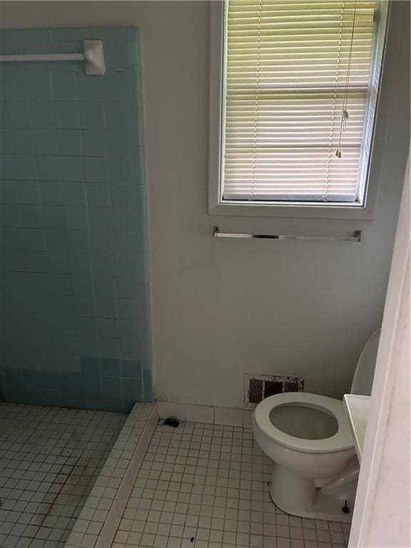 bathroom featuring walk in shower, tile patterned flooring, and toilet