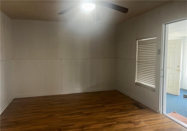 spare room with dark wood-type flooring and ceiling fan